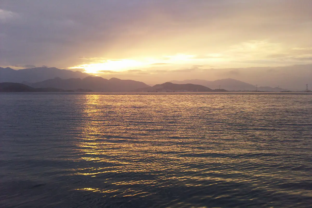 Hoàng hôn trên vịnh Nha Trang nhìn từ đảo Hòn Tre về phía đất liền, mặt trời khuất sau dãy núi phía tây, ánh vàng trải trên mặt nước, ảnh đăng tháng 4/2010