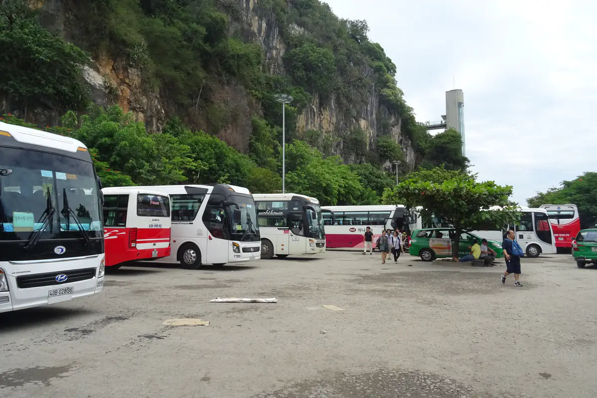 Coaches and tour vans parked in the lot beside the cliffs of Thuy Son, Marble Mountains, Da Nang