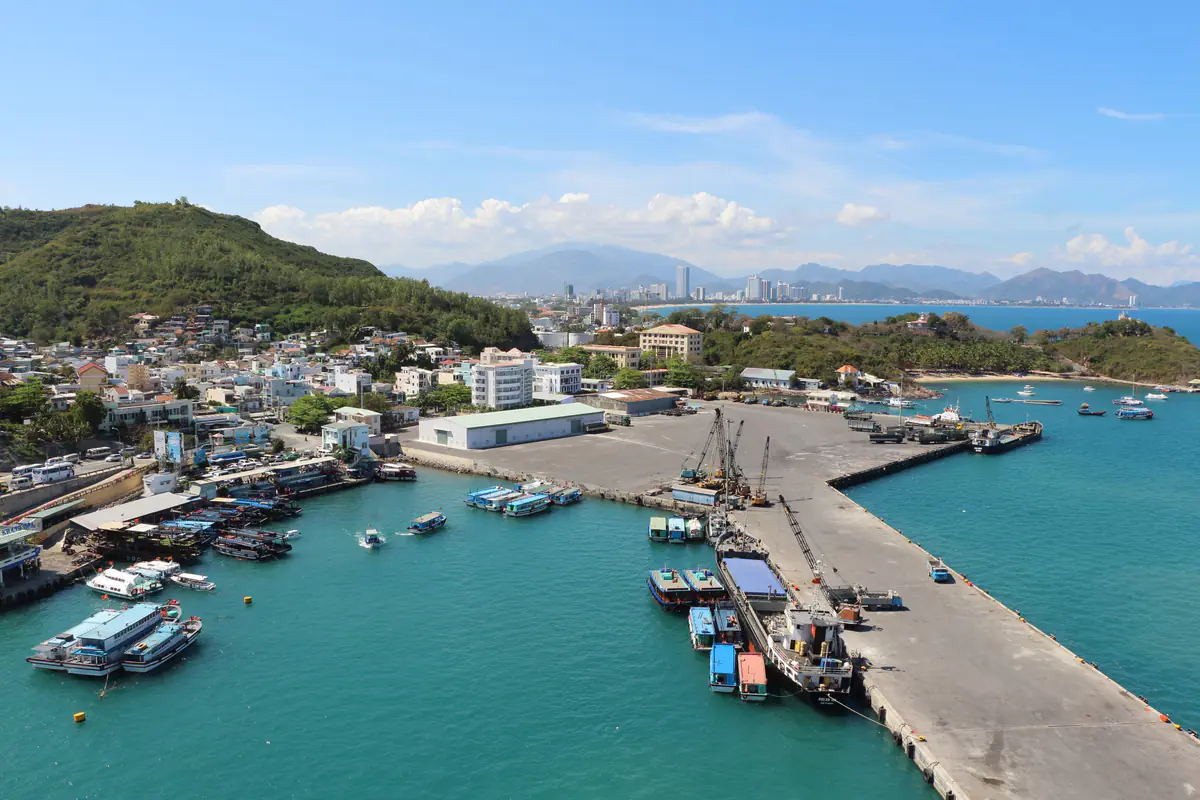 Cảng Nha Trang ở khu Cầu Đá nhìn từ trên cao, tàu du lịch và tàu hàng neo dọc kè, phía xa là dãy cao ốc ven biển, tháng 3/2015