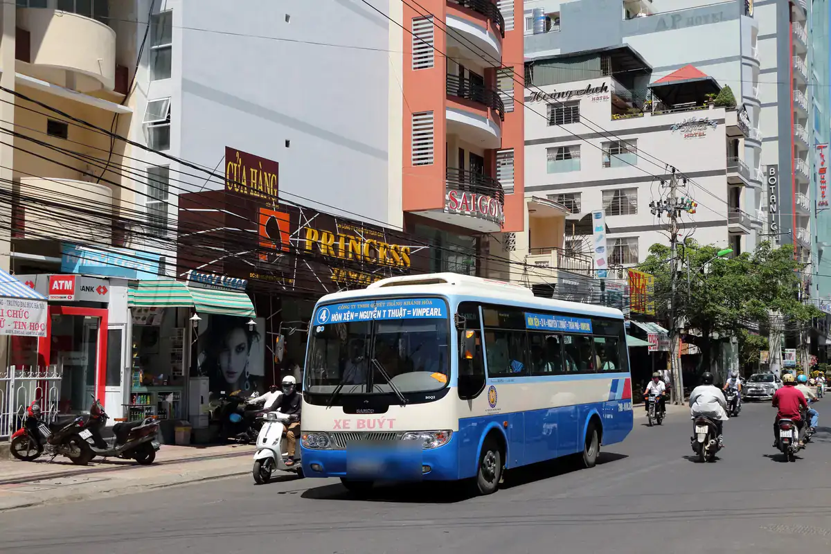 Xe buýt nội thành màu xanh trắng, bảng tuyến Hòn Xện - Nguyễn Thiện Thuật - Vinpearl, chạy giữa phố khách sạn ở Nha Trang, tháng 3/2015