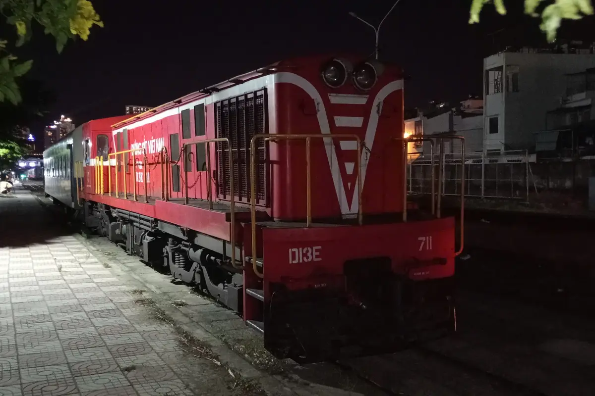 Đầu máy D13E màu đỏ và toa xe đỗ trên đường ray ga Nha Trang về đêm, tháng 8/2025
