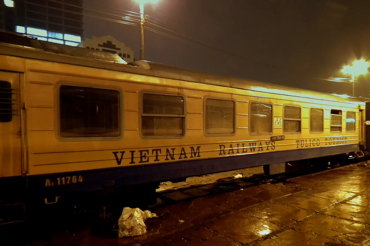 Toa giường nằm sơn vàng của tàu đêm đi Lào Cai đỗ bên sân ga Hà Nội lúc trời tối, mặt sân ướt mưa, tháng 2/2012