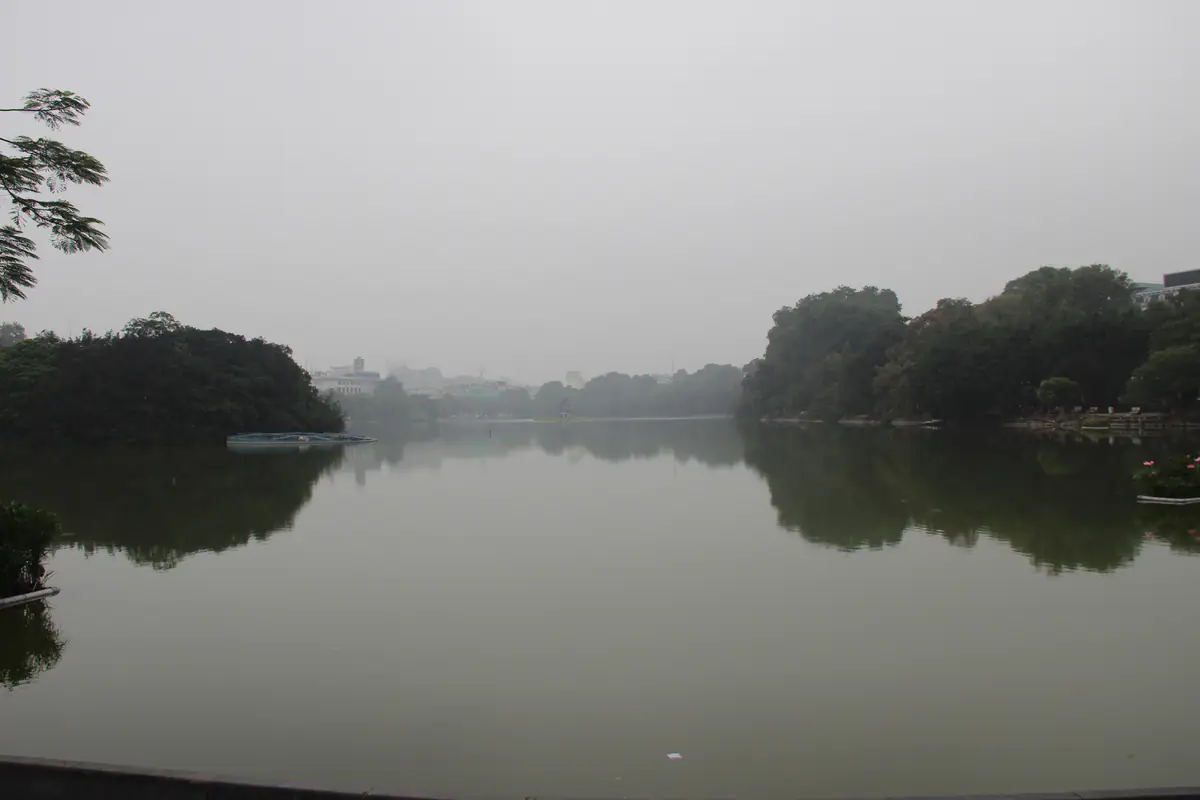 Mặt hồ Hoàn Kiếm phẳng lặng dưới bầu trời xám mù, nhà cửa phía xa mờ nhạt, chiều 30/11/2012